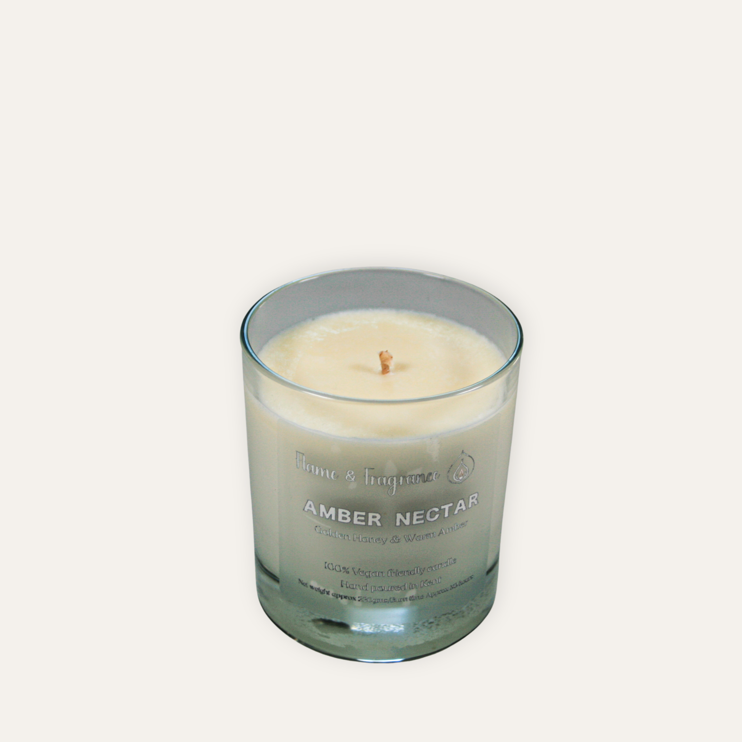 Candle in a glass jar labeled 'Amber Nectar' on a white background