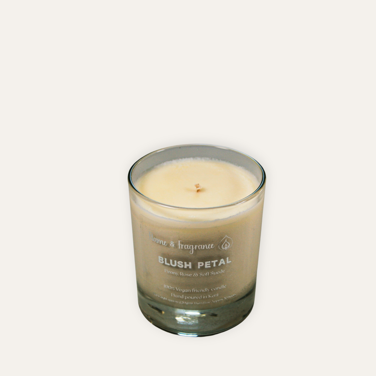 Candle in a glass jar labeled 'Blush Petal' on a white background