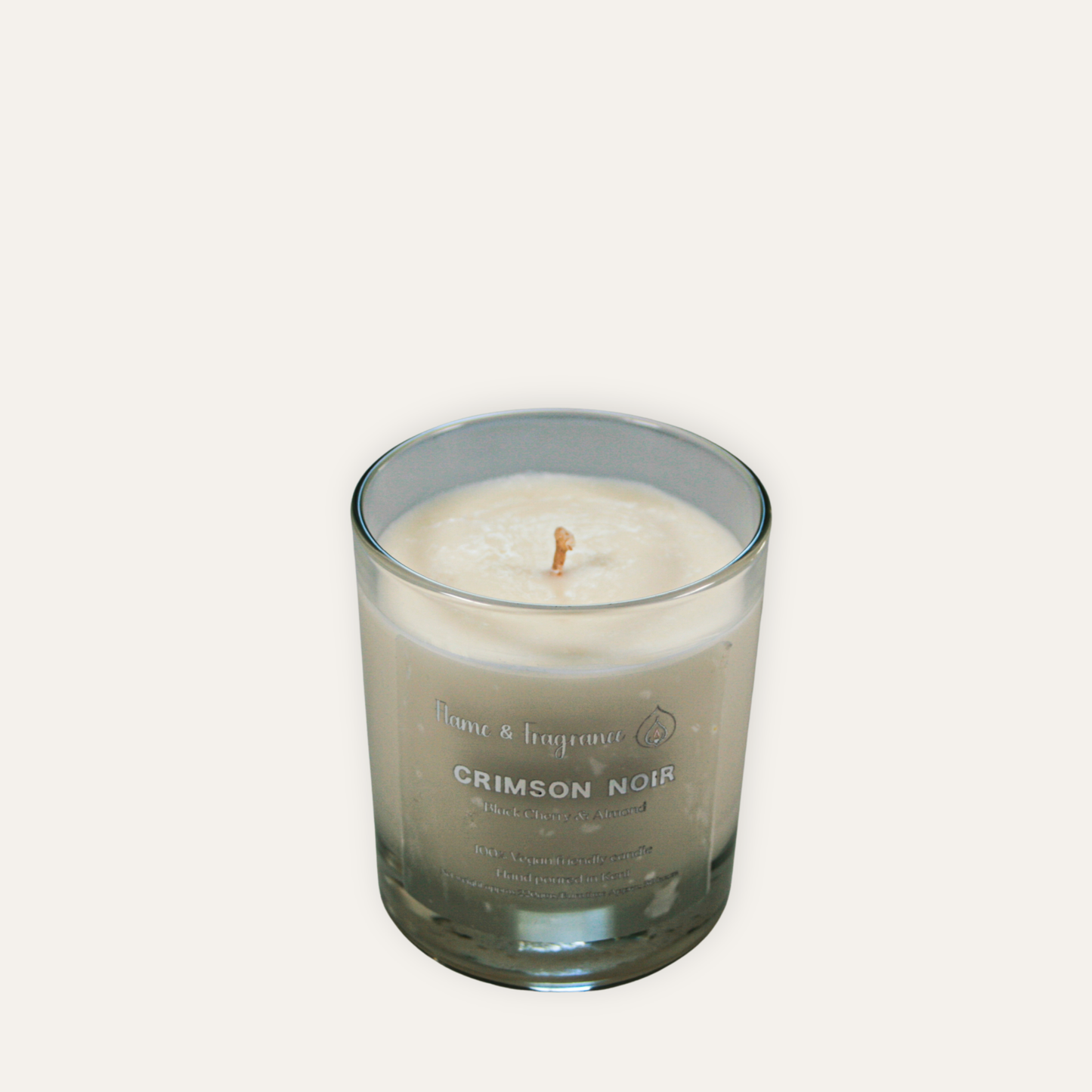 Candle in a glass jar labeled 'Crimson Noir' on a white background