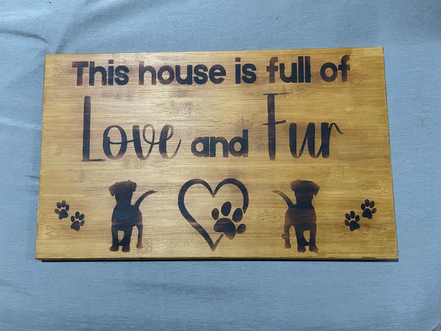 Wooden sign with burnt text and graphics lying on a blue background