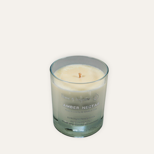 Candle in a glass jar labeled 'Amber Nectar' on a white background