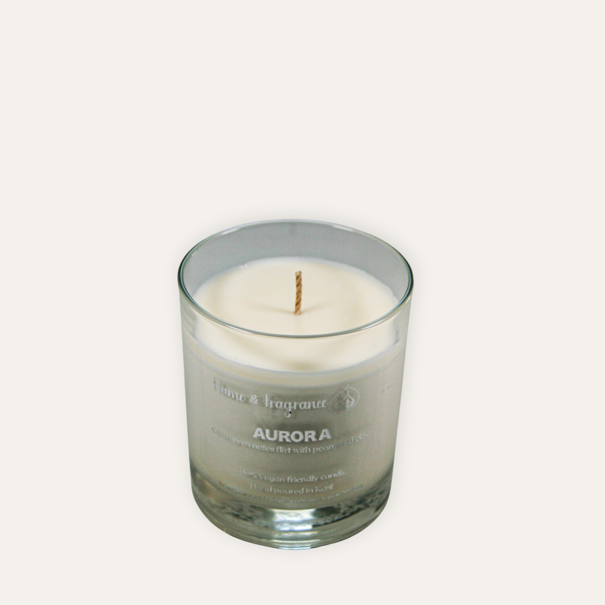 Glass candle with 'Aurora' branding on a white background