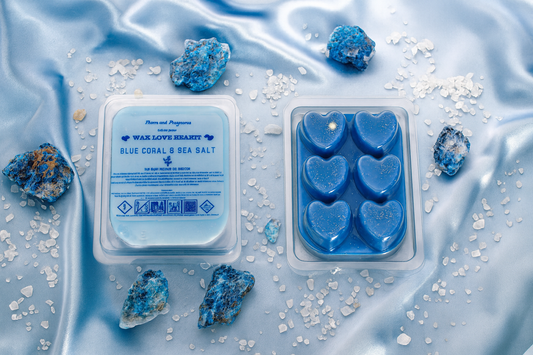 Blue heart-shaped wax melts in packaging on a blue fabric background with sea salt and crystals.