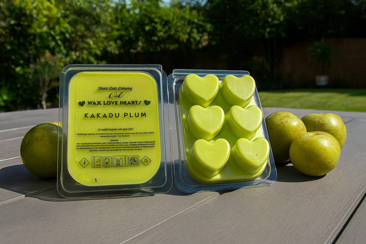Packaged heart-shaped wax melts labeled 'Kakadu Plum' on a wooden surface with  Kakadu Plums.