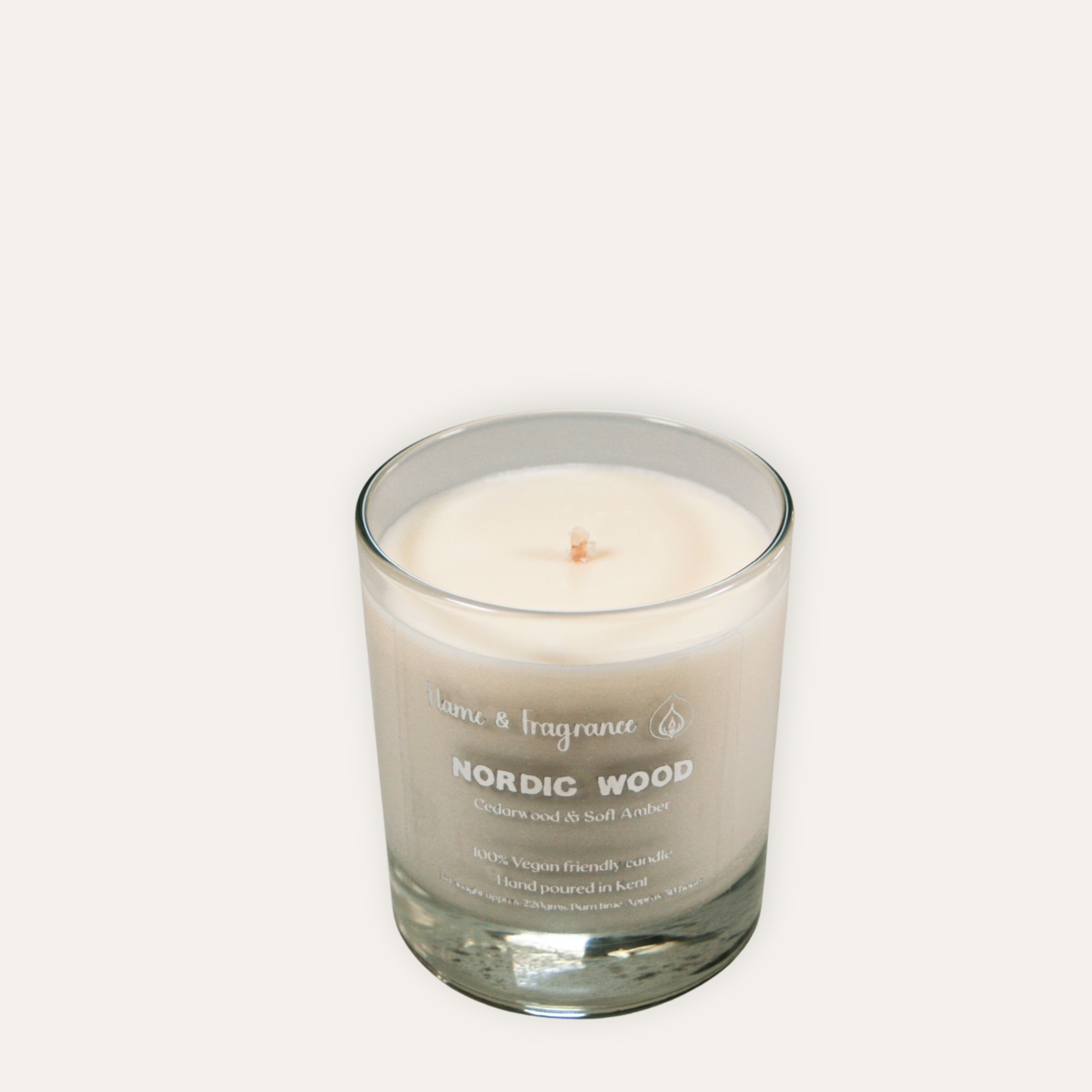 Candle in a glass jar labeled 'Nordic Wood' on a white background