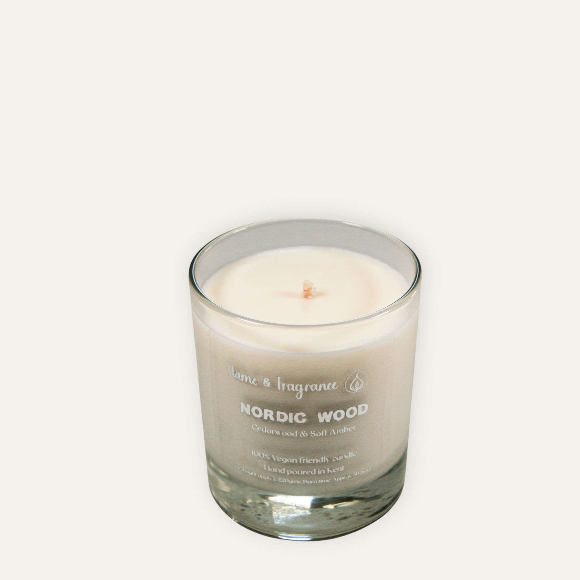 Candle in a glass jar labeled 'Nordic Wood' on a white background
