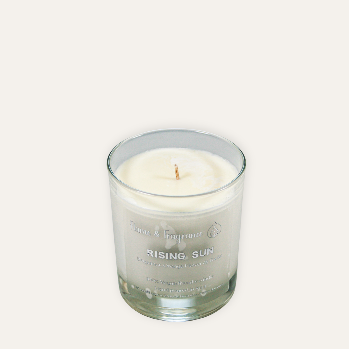 Glass candle labeled 'Rising Sun' on a white background