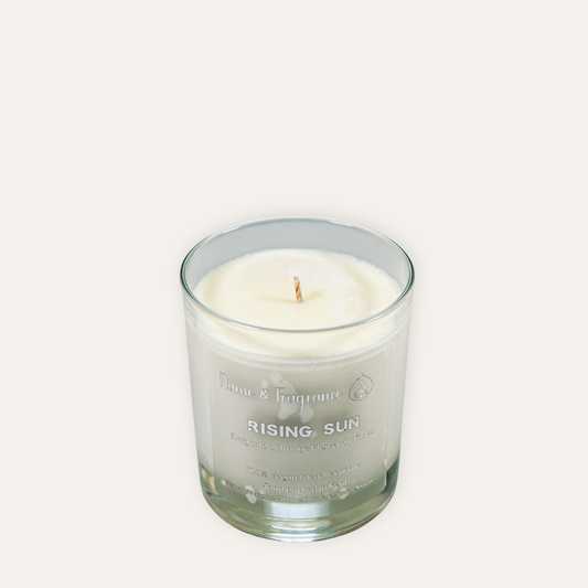 Glass candle labeled 'Rising Sun' on a white background