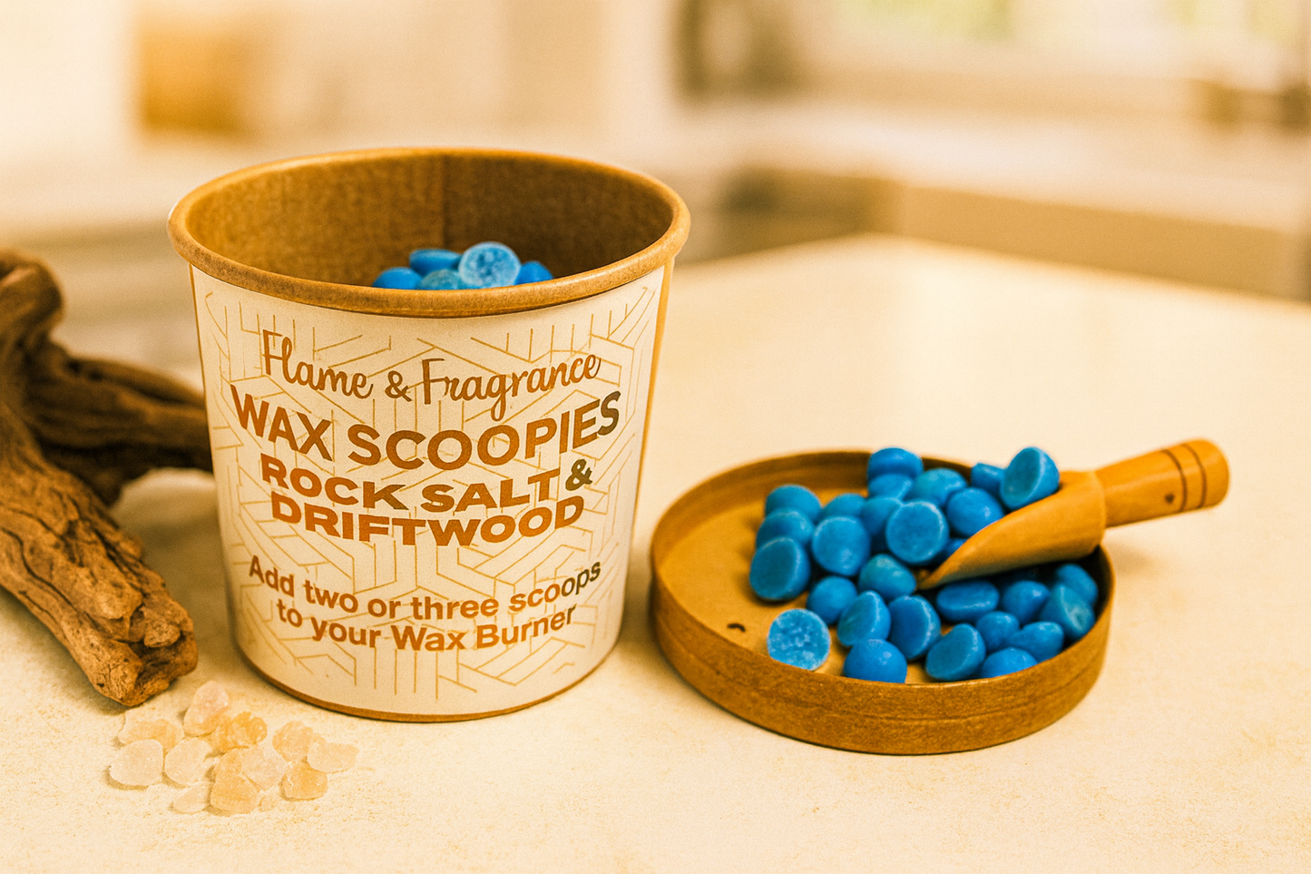 Blue Wax scoopies in a container labeled 'Rock Salt & Driftwood' on a wooden surface.