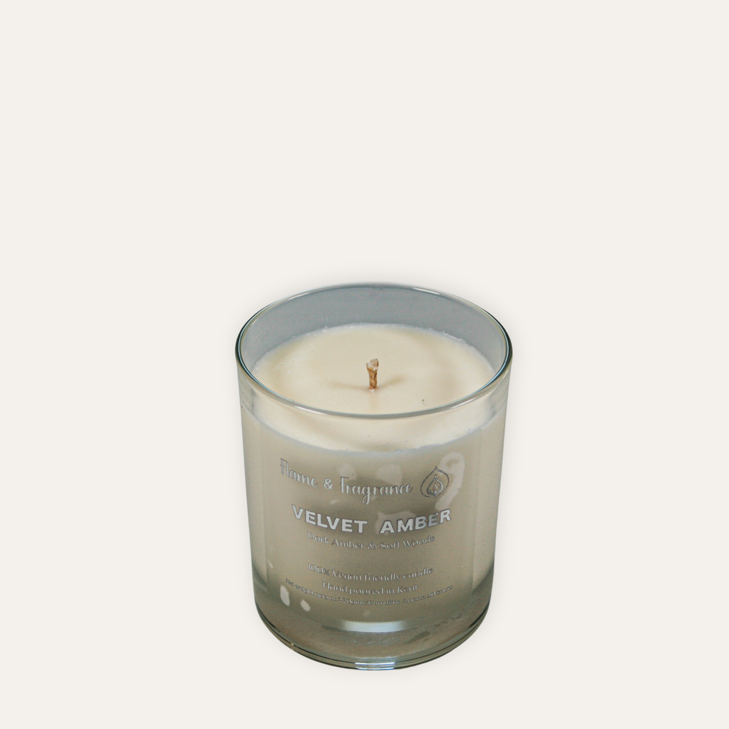 Candle in a glass jar labeled 'Velvet Amber' on a white background