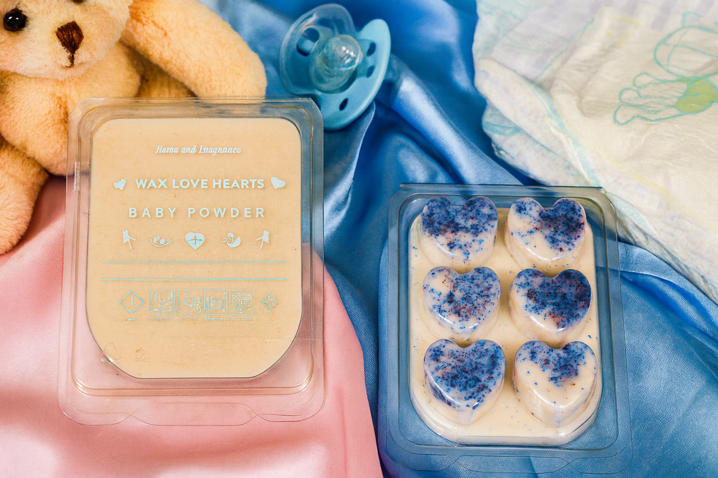 Wax melts labelled 'Baby Powder' with a teddy bear and a baby's dummy in the background.