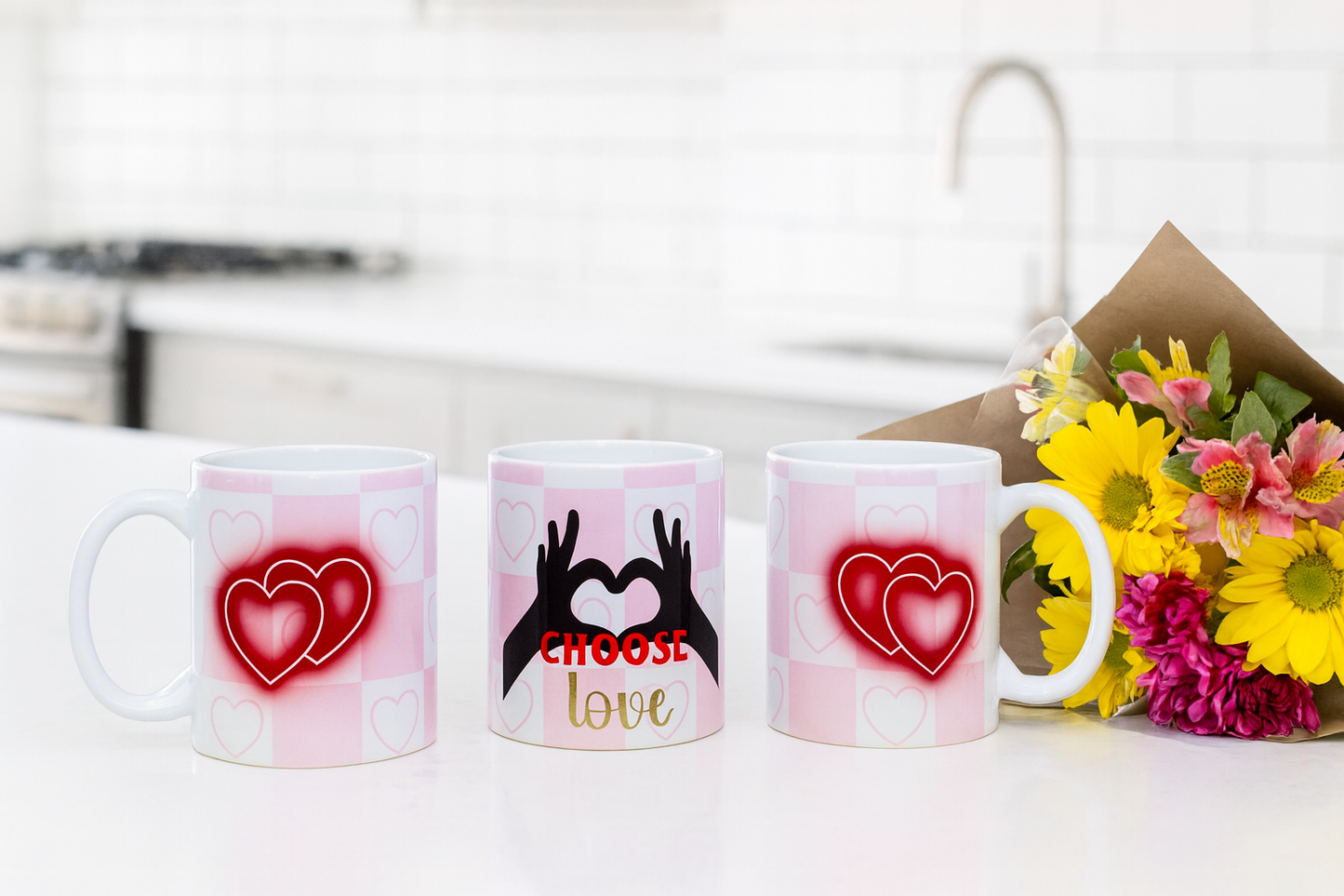 Three views of a mug showing the heart and hand designs on a white surface with flowers.